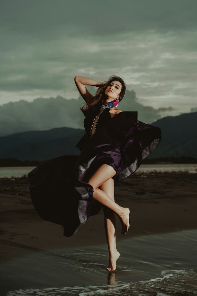 Woman wearing a purple dress standing on the shoreline